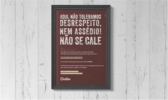 Quadro impresso do Empório Cervisia com aviso de tolerância zero a assédio, emoldurado na parede