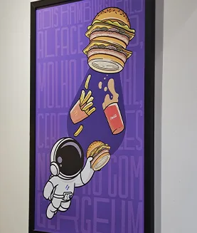 Quadro ilustrado exclusivo da Moinho, com astronauta e referência à música do Big Mac, na copa do escritório